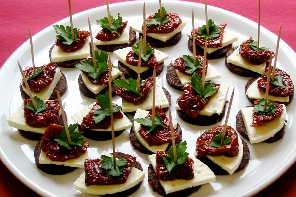 Pumpernickeltaler mit Schafskaese und getrockneten Tomaten